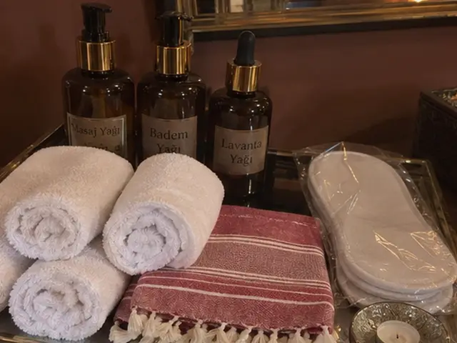 Masaj yağları, rulo havlular, kırmızı çizgili peştemal ve terlik — Camlıkahve, Masaj Salonun